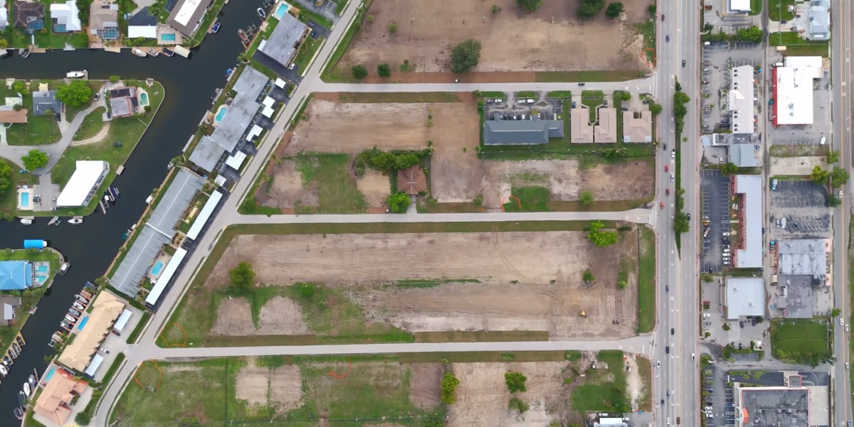 Cleared Bimini East parcels. The straight-down aerial shows the cleared development blocks, existing streets and the canal-front homes along the western edge of the project area.